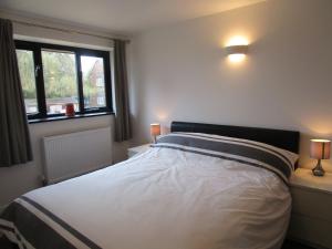 a bedroom with a large bed with two windows at Ash Barn - Fernhill Farm in Ryde