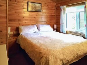 a bedroom with a bed with a wooden wall at Bewick Lodge in Keswick +8 photos