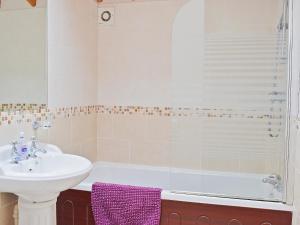 a bathroom with a sink and a toilet and a tub at Magpie Cottage in Gristhorpe