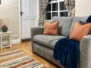 a living room with a gray couch with orange pillows at The Farriers - 26967 in Windermere