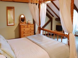 a bedroom with a bed and a dresser and a mirror at Jasmine Cottage - E1493 in Scalby