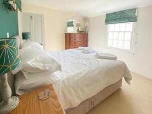 Un dormitorio con una gran cama blanca y una ventana. en The Chatham - 30164, en Lyme Regis 6 fotos más