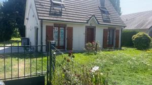 a small white house with a fence in the yard at Maison Bourg-Achard in Bourg-Achard