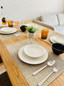 a wooden table with white plates and spoons on it at VJ House in Fukuoka