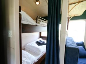 a room with two bunk beds and a blue curtain at Railway Carriage One - E5337 in Wetheringsett