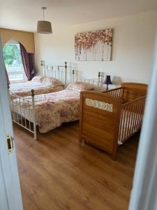 a bedroom with two beds and a crib at The Old Parochial House in Speenoge +5 photos