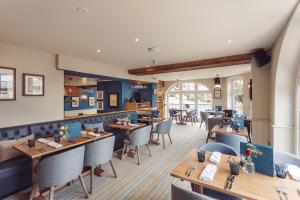 a restaurant with wooden tables and chairs at The Ship Hotel in Southend-on-Sea