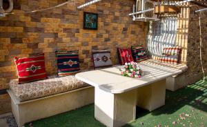 a group of pillows on a bench in a patio at Luxurious Family Apartment in Prime New Cairo with Garden in Cairo