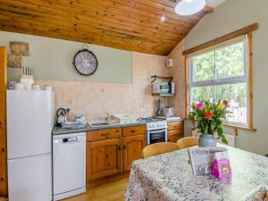a kitchen with a table and a white refrigerator at Spinnaker - 16828 in Staithes