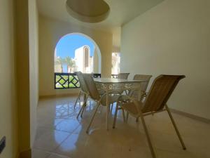 a dining room with a table and chairs and a window at SHL Hurghada Hotel Apartments Sahl Hasheesh - By SAHLHOMES in Hurghada