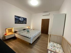 a small bedroom with a bed and a crib at Art Design Gallery - Bratislava city center in Bratislava