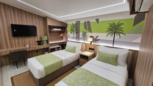Una habitación de hotel con dos camas y un televisor de pantalla plana. en Lime Resort Bohol, en Panglao