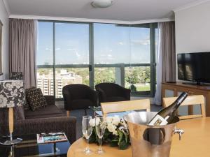 a living room with a bottle of wine on a table at The Sebel Sydney Chatswood in Sydney