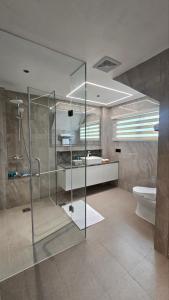 Un baño con ducha de cristal y un inodoro. en Lime Resort Bohol, en Panglao