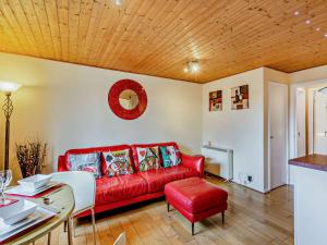 Una sala de estar con un sofá rojo y una mesa. en Strawberries And Cream, en Bowness-on-Windermere