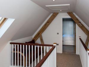 a staircase in a house with wooden beams at West Barns - Fernhill Farm in Wootton Bridge