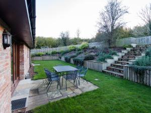 a patio with a table and chairs in a yard at West Barns - Fernhill Farm in Wootton Bridge +17 photos