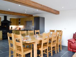 a kitchen and dining room with a wooden table and chairs at Pistyll Gwyn in Llanwrthwl +27 photos