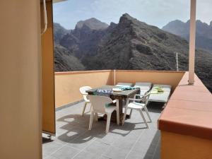 a table and chairs on a balcony with a mountain view at LAS 7 ISLAS, BARRANCO DE ADEJE in Adeje