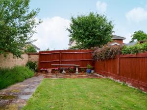 un patio trasero con una mesa de picnic y una valla en Marina View, en East Cowes