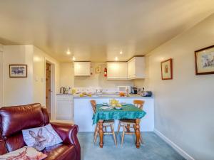 a small kitchen with a table and a couch at Blossom Cottage in Goldsborough