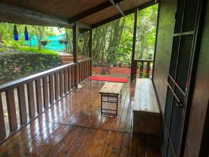 un portico di una casa con una panchina sopra di Trekkingtrails woodhouse a Jāmb