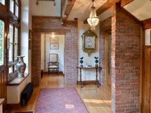 sala de estar con pared de ladrillo y lámpara de araña en Dove Cote House, en Westleigh 15 fotos más