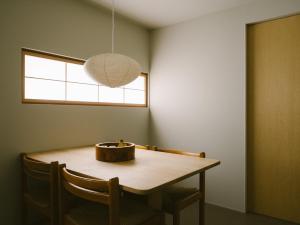 a dining room table with a pendant light at YALDA apartment in Kanazawa