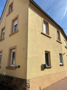 a yellow building with windows on the side of it at Schönes Studio mit Küche, frisch renoviert in Walsheim