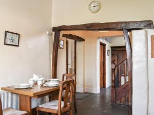 a dining room with a wooden table and chairs at Yew Tree Cottage in Windermere
