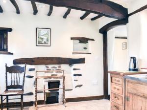 a kitchen with a chair and a fireplace at Stable Cottage in Windermere