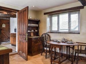 a dining room with a table and chairs and a window at Stable Cottage in Windermere