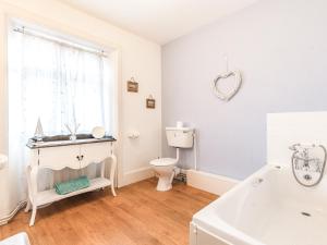 a bathroom with a toilet and a sink and a tub at Church View in Hunstanton +10 photos