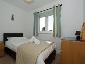 a bedroom with two beds and a window at 6 Jubilee Close in St Merryn