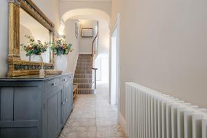 a hallway with a blue cabinet and a mirror and stairs at Stunning Townhouse & Basement in Leamington Spa in Leamington Spa +82 photos