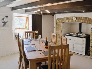 a dining room with a table with chairs and a kitchen at Dover Row Cottage in Zelah
