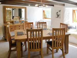 a dining room with a wooden table and chairs at Dover Row Cottage in Zelah