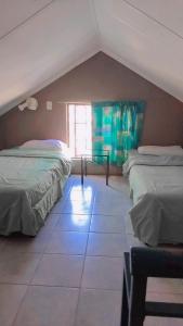 a attic room with two beds and a window at 27 Pendleberry Grove, Chris Hani Drive, Bela-Bela in Bela-Bela +11 photos