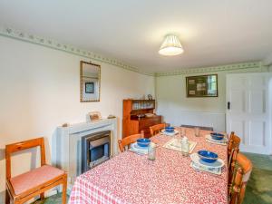 een eetkamer met een tafel en een open haard bij Haweswater Cottage in Bampton +27 foto's