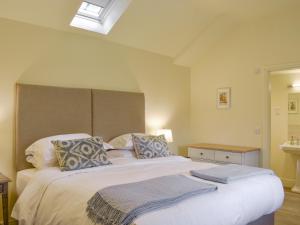 a bedroom with a large white bed with two pillows at Tiggywinkle Cottage in Hawnby +26 photos