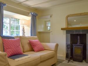 a living room with a couch and a fireplace at Tiggywinkle Cottage in Hawnby