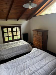 1 Schlafzimmer mit 2 Betten, einer Kommode und einem Fenster in der Unterkunft Aneley Cabañas Bosque Peralta Ramos in Mar del Plata + 21 Fotos
