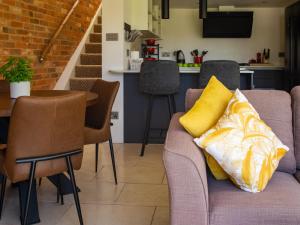 ein Wohnzimmer mit einem Sofa und gelben Kissen in der Unterkunft Mallard Cottage in Winchester + 18 Fotos