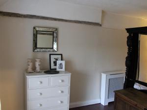 une chambre avec une commode et un miroir dans l'établissement Lavender Cottage, à Methwold