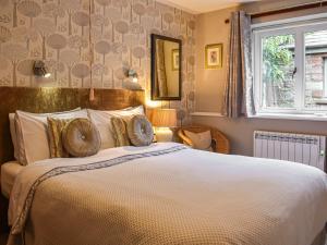a bedroom with a large bed and a window at Riverbank Cottage in Pooley Bridge