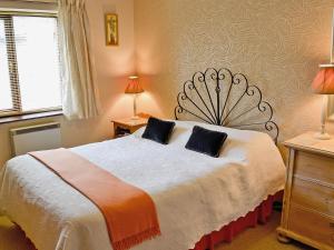 a bedroom with a bed with two pillows on it at Riverbank Cottage in Pooley Bridge
