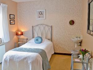 a bedroom with a bed and a sink at Riverbank Cottage in Pooley Bridge +19 photos