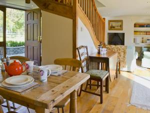 Un comedor con mesa y sillas de madera. en The Linhay, en Westleigh