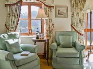 Una sala de estar con dos sillas y una ventana. en The Linhay, en Westleigh