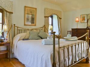 1 dormitorio con 1 cama con sábanas blancas y 2 ventanas en The Linhay, en Westleigh 6 fotos más